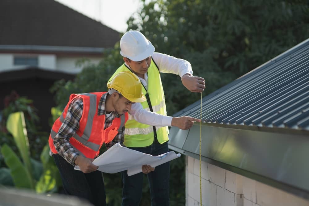Civil engineer with personal safety equipment checking and consult with construction site foreman technician for inspect building construct process during follow up process. Engineering concept.